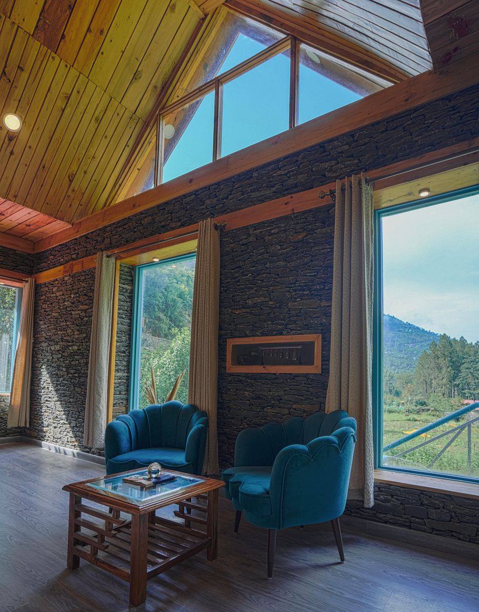 First-floor lounge with velvet armchairs and mountain windows