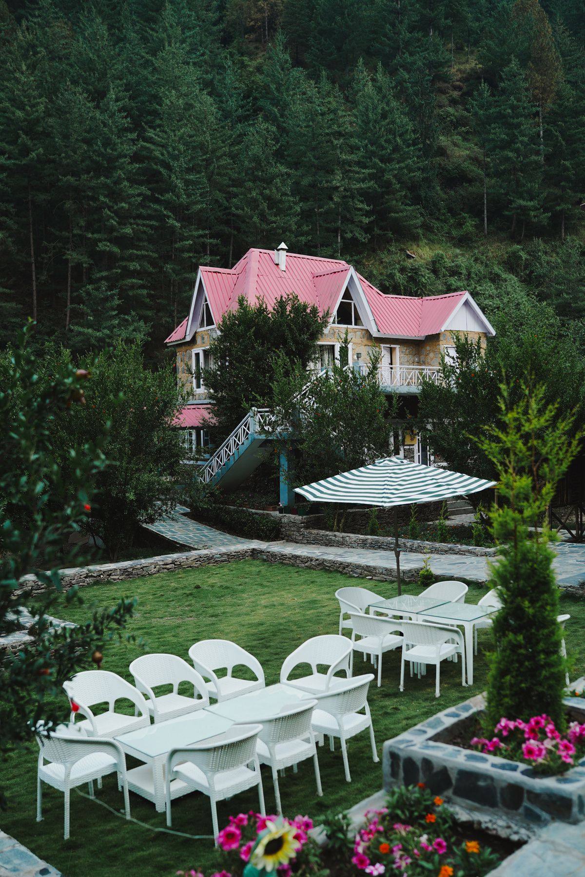Lawn with white chairs in front of a villa