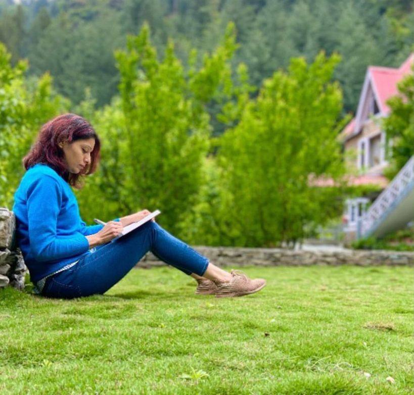 Guest reading on the lawn beside a villa