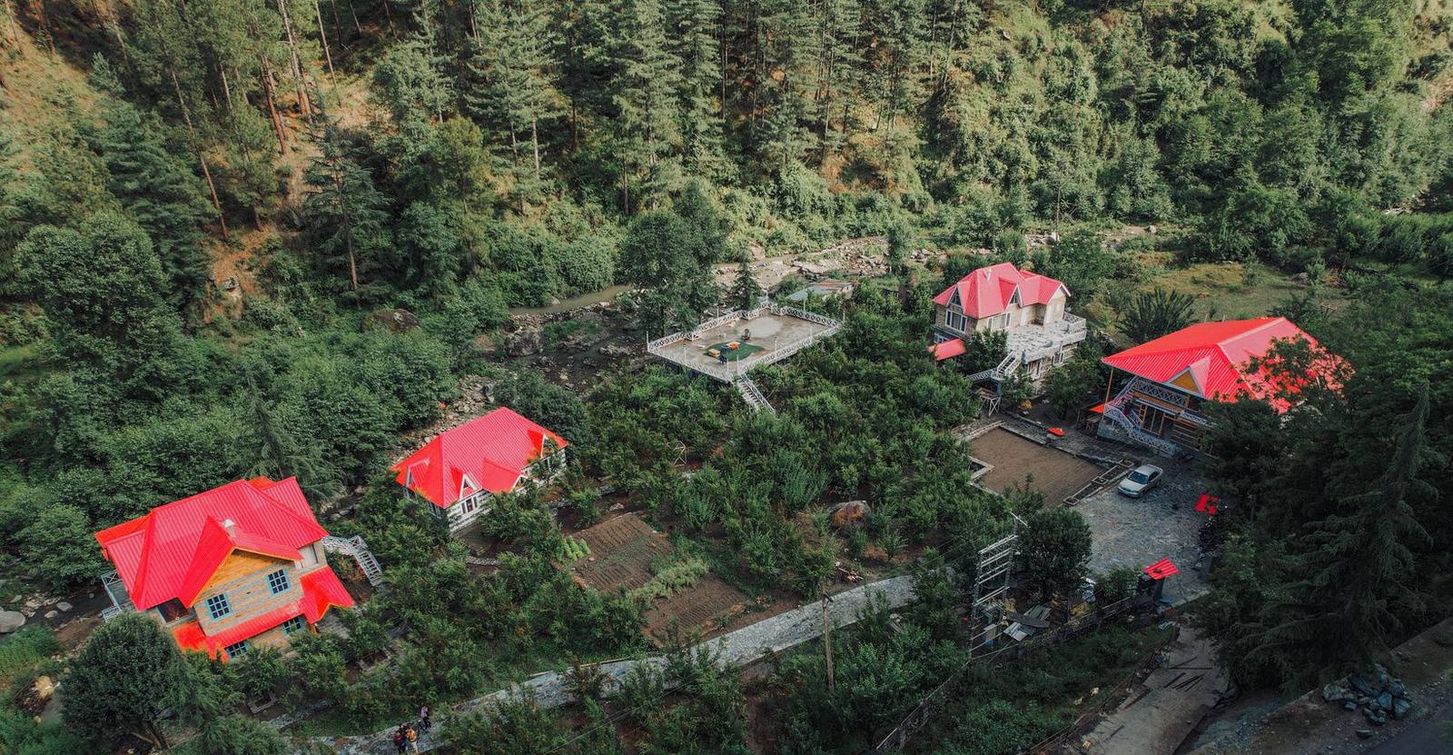 Aerial view of Anandgram’s four red-roofed villas in the orchard